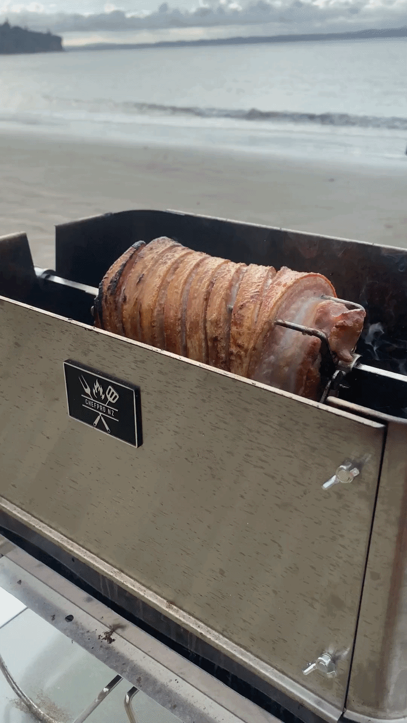 ChefPro NZ Weber GA rotisserie pork roll cooking on beach 